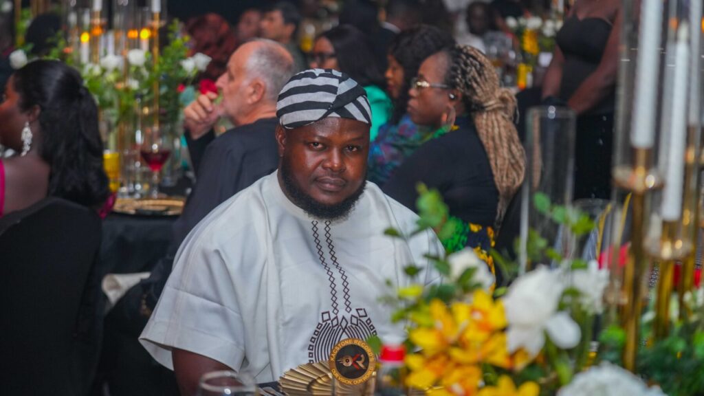 A guest in a white smock seated at the launch dinner